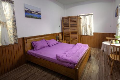 a bedroom with a bed with purple sheets at Sea-Breeze Homestay in Phan Thiet