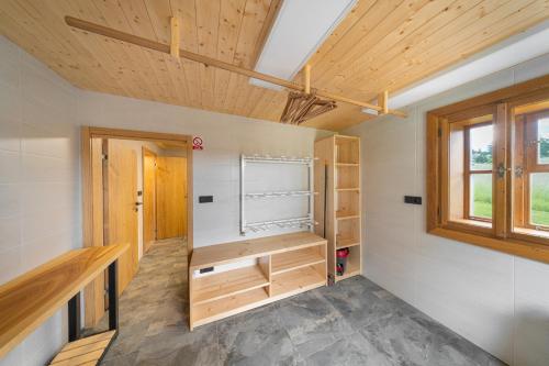 a room with wooden cabinets and a window at Roubenka Růženka - Říčky v Orlických horách in Wüstenei