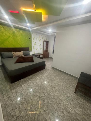 a bedroom with a bed and a green wall at Mountainmist Holidays in Ramakkalmedu