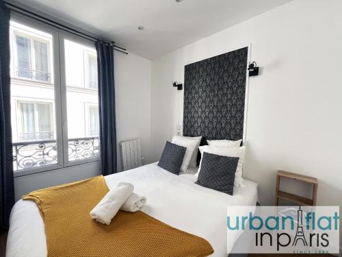 une chambre avec un lit blanc avec une grande fenêtre dans l'établissement Urban Flat 17 - Pretty 3 Bedroom Flat in Paris, à Paris