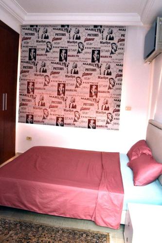 a bed in a room with a wall with avertisement at Superbe appartement au coeur de la Marsa in Tunis