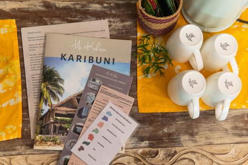 a table with a book and some papers and some eggs at Mr Kahawa in Paje