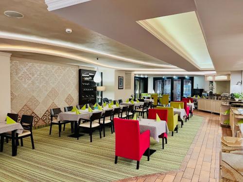 a restaurant with red and yellow chairs and tables at Papuga Park Hotel Wellness Marrakesz & SPA in Bielsko-Biala