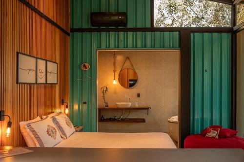 a bedroom with green curtains and a bed and a sink at Pousada Sitio Raizes in Siderópolis