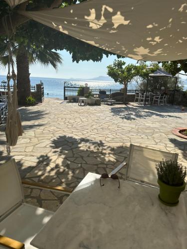 a table with glasses on it next to the beach at Sea You - Apartments in Avlákia