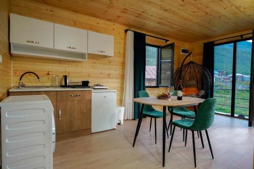 una cucina con tavolo e sedie verdi in una stanza di Ushguli Highland Cottage a Ushguli