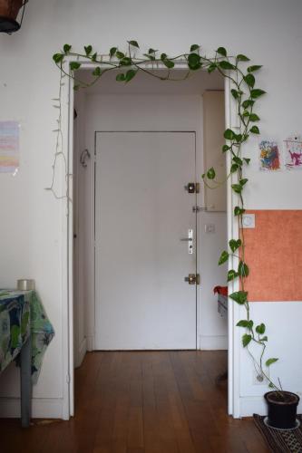 une porte blanche avec une plante sur elle dans l'établissement La fourmi de Montmartre, à Paris