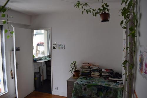 une chambre avec une table, des livres et des plantes dans l'établissement La fourmi de Montmartre, à Paris