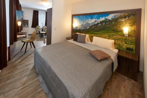 a bedroom with a bed with a large painting on the wall at Gästehaus Stiftsstadt in Kempten