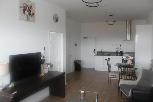 a living room with a television and a dining room at Flat 409 One bedroom apartment in Birmingham