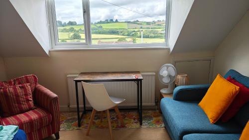 a living room with a table and a window at Aller Park, Newton Abbot in Newton Abbot
