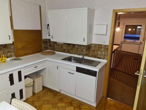 MittenaarにあるNature Park, 2 Double, 1 sofa for sleeping in 3 rooms, Kitchen, Bathroomの白いキャビネットとシンクのあるキッチン