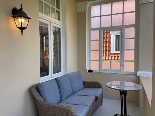 a living room with a blue couch and a table at Villa Deichvoigt in Cuxhaven