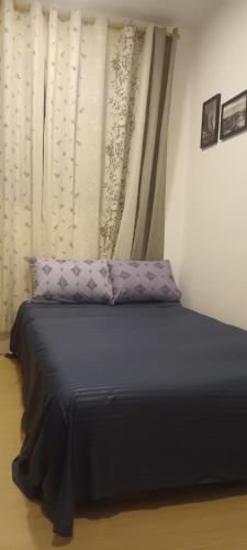 a bed with purple pillows in a room with a curtain at 024 - Apto Studio Liberdade Sé 500'Metrô in Sao Paulo