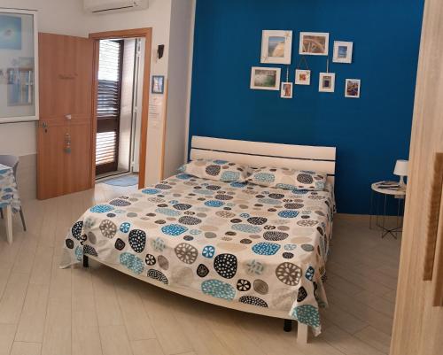a bedroom with a bed with a blue wall at Monolocale BLU MARE in Macari