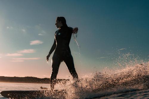 a woman riding a wave on a surfboard in the ocean at Kyuka Surfclub in Lajares
