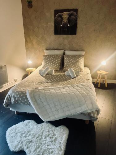 une chambre avec un grand lit avec des draps et des oreillers blancs dans l'établissement Bel appartement en plein cœur du vieux Troyes., à Troyes