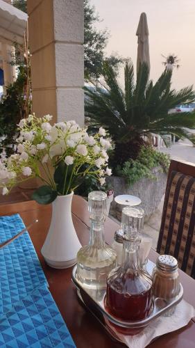 a table with two glass bottles on a tray with flowers at Workation Panorama Escape in Budva