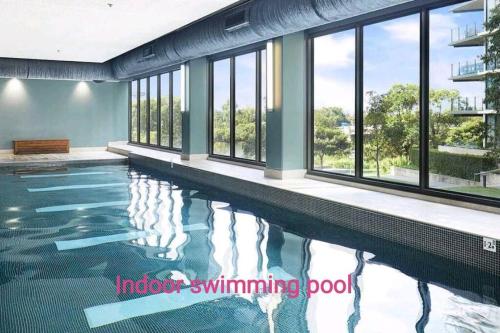 a swimming pool in a building with windows at Lakeview Luxury 3Bedrooms Apt Wolli Creek close to Airport CBD in Sydney