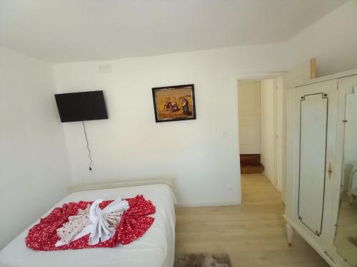 a bedroom with a bed with a red blanket on it at Les jardins secrets in Romilly-sur-Seine