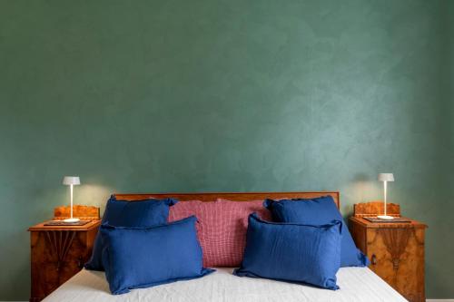 a bed with blue pillows and a green wall at Ca' Giorgio - Dolo in Dolo
