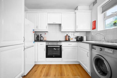 cocina blanca con armarios blancos y lavavajillas en Stylish Two Bedroom House - Parking - Garden 55H, en Birmingham