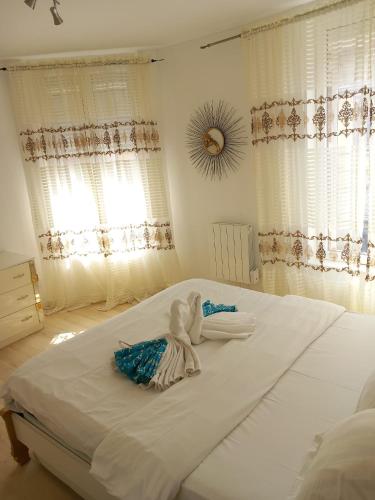 - un grand lit blanc dans une chambre avec fenêtres dans l'établissement Les jardins secrets, à Romilly-sur-Seine