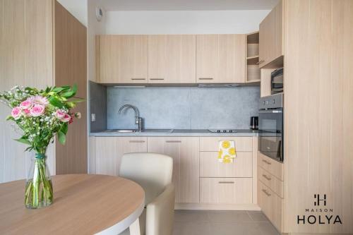 une cuisine avec une table et un vase de fleurs dans l'établissement À Avignon - Le Reposant - 373B, à Avignon