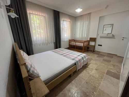 a bedroom with a bed and a crib in it at Villa Oasis Taşın Zarafeti,Modern Rahatlık in Dalaman