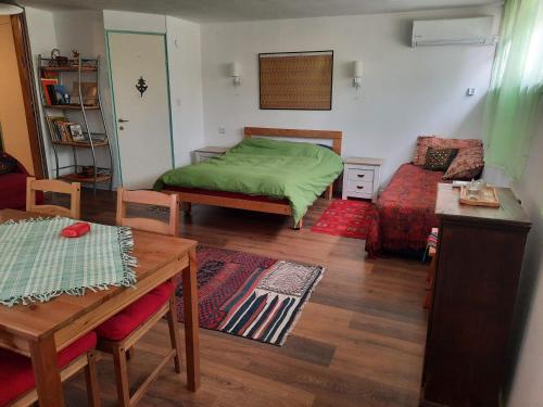 a bedroom with a green bed and a table at הבית הירוק - Green House in Arad