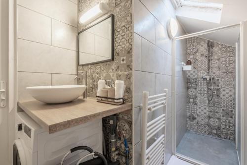 a bathroom with a sink and a mirror and a shower at le Duplex des voyageurs in Aubervilliers