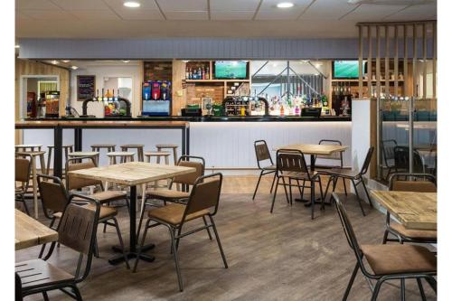a restaurant with tables and chairs and a bar at Tencreek Holiday Park in Looe