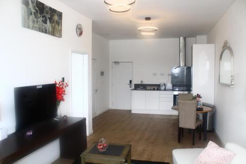 a living room with a table and a kitchen at Flat 404 One bedroom apartment in Birmingham