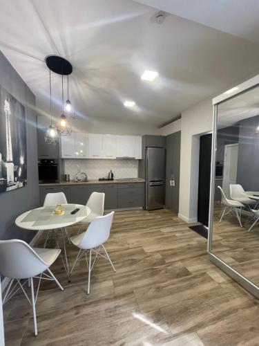 a kitchen and dining room with a table and chairs at Gabriela Central Apartment in Satu Mare