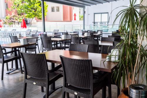 an empty restaurant with wooden tables and chairs at Marmaris Alkan Hotel in Marmaris