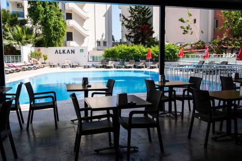 a restaurant with tables and chairs next to a swimming pool at Marmaris Alkan Hotel in Marmaris