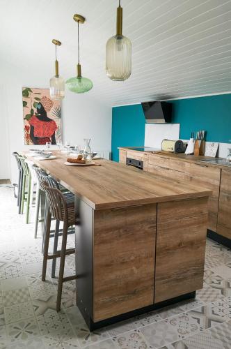 une cuisine avec un grand îlot en bois et des tabourets de bar dans l'établissement Maison au Vieil à 200m de la mer, à Noirmoutier-en-l'lle