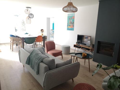 un soggiorno con un divano e un tavolo di Maison au Vieil à 200m de la mer a Noirmoutier-en-l'lle