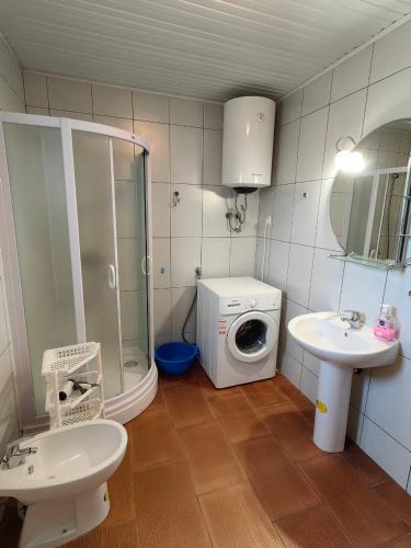 a bathroom with a washer and a sink and a washing machine at Romantic auch mit Kindern in Sutomore