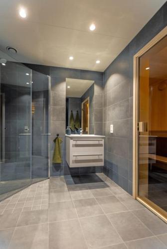 a bathroom with a shower and a sink and a mirror at Skistadion Hafjell in Hafjell