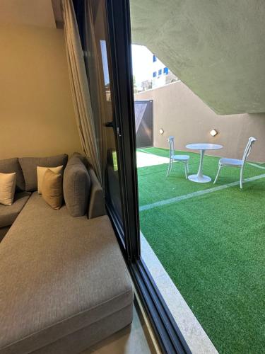 a living room with a couch and a table at Chic Apartments For Rent ave0-1 in Umm Uthainah