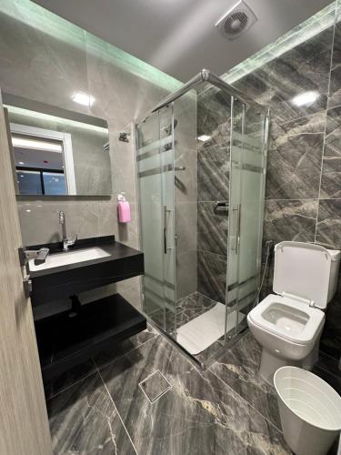 a bathroom with a shower and a toilet and a sink at Chic Apartments For Rent ave0-1 in Umm Uthainah