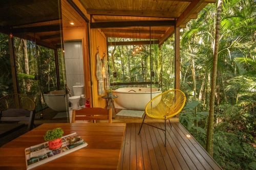 a bathroom with a tub and a table and chairs at Pousada Sitio Raizes in Siderópolis