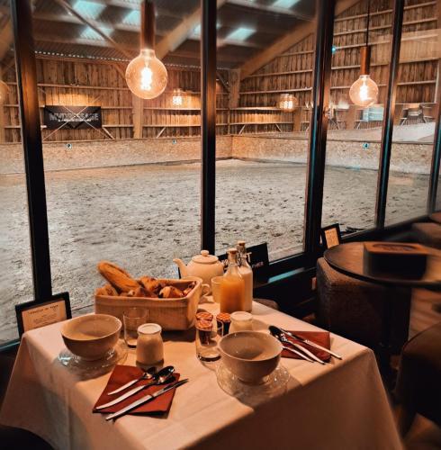 a table in a restaurant with a view of the snow at Manège de la Chapinière - DadaLoge tiny-house in Châteauvieux