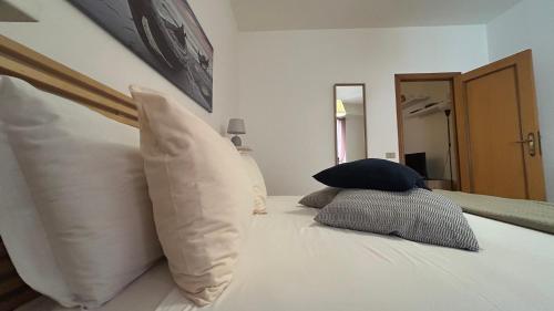 a bed with four pillows on top of it at Ankon Apartments Palazzo Mazzini in Ancona