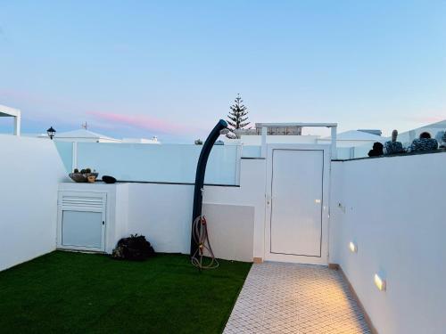 a hose on the side of a house with grass at Garden House, Playa Honda in Arrecife