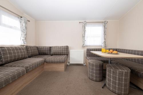 a living room with a couch and a table at Tencreek Holiday Park in Looe