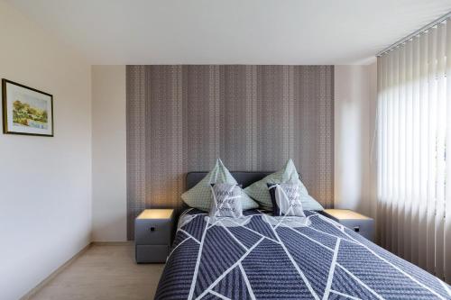 a bedroom with a bed with a blue comforter and pillows at Ruhiges Appartement Am Stadtrand in Kevelaer