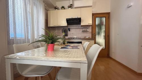 a kitchen with a white table and white chairs at Ankon Apartments Palazzo Mazzini in Ancona