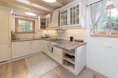 a kitchen with white cabinets and a counter top at Luxury Villa TINKA in Zgornje Gorje